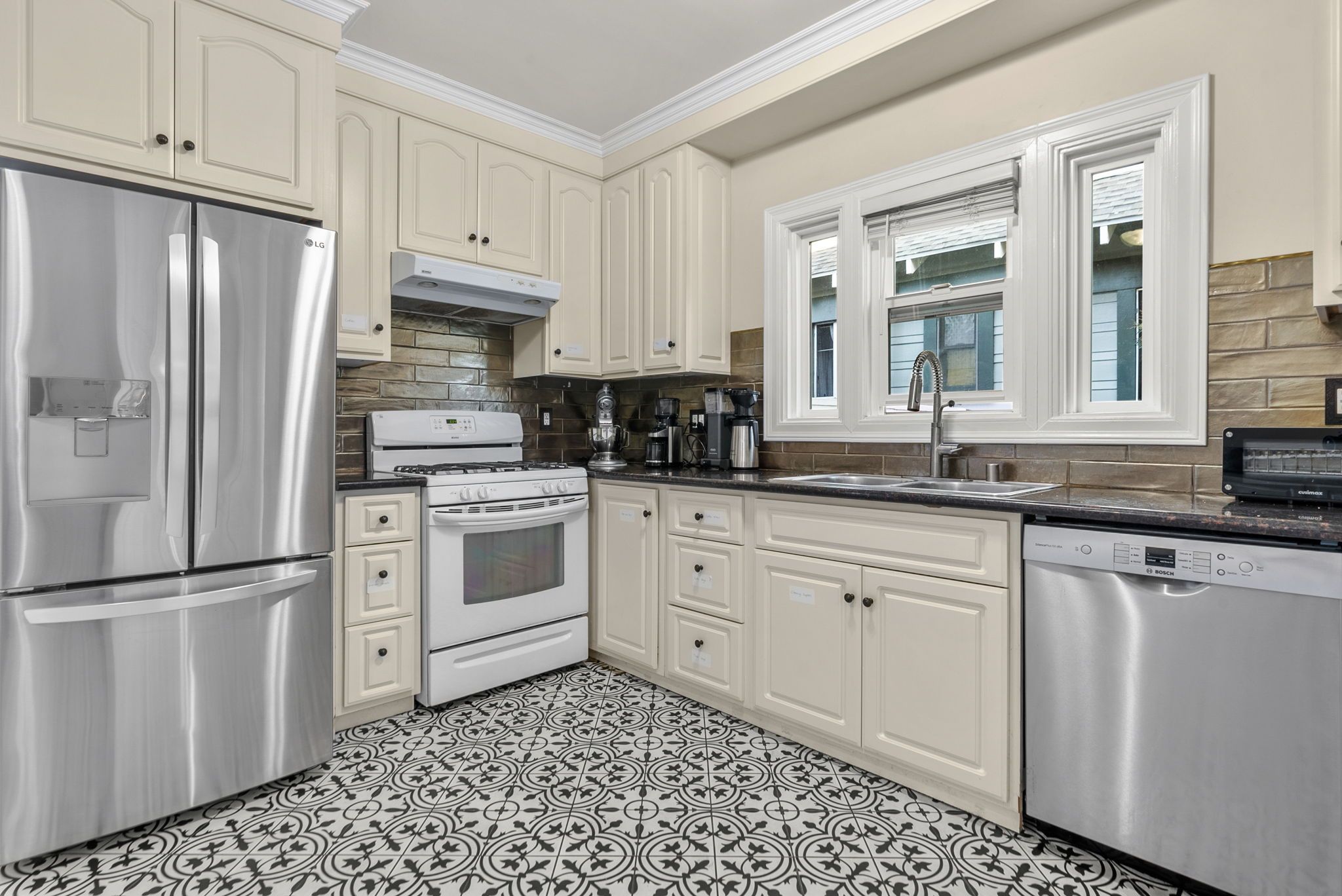 Kitchen with patterned tile floor and stainless appliances
