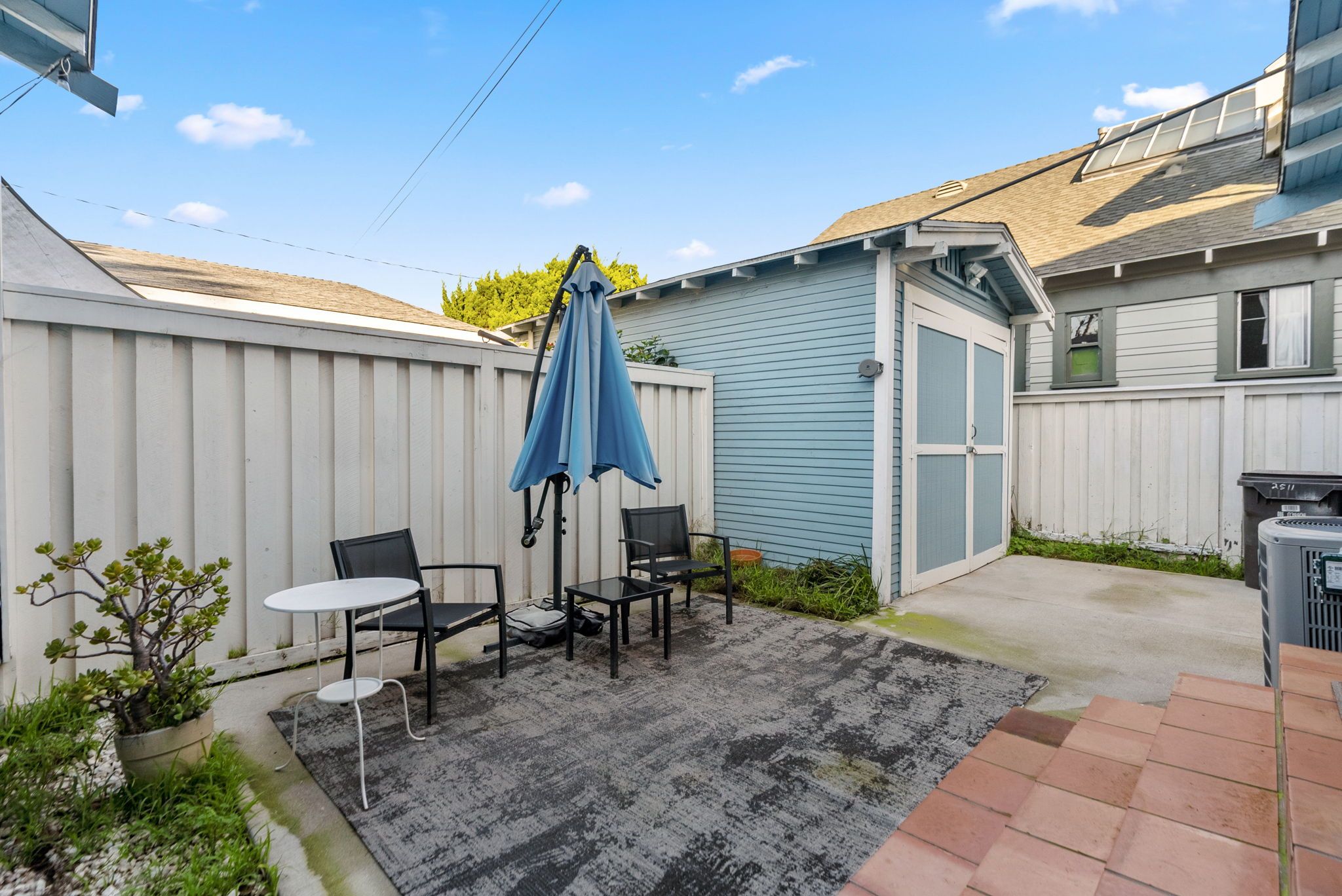 Private back patio with a table and umbrella